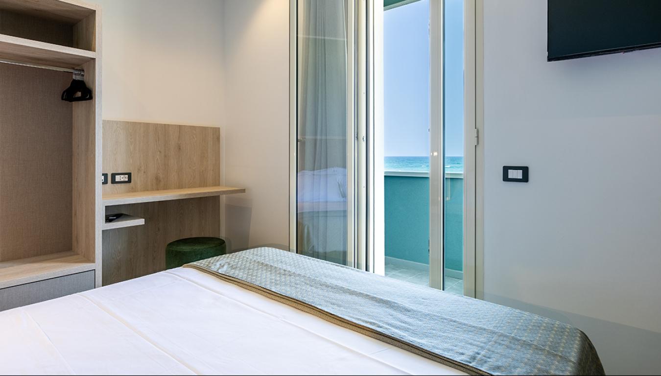 Camera luminosa con vista mare, atmosfera rilassante e arredi moderni.