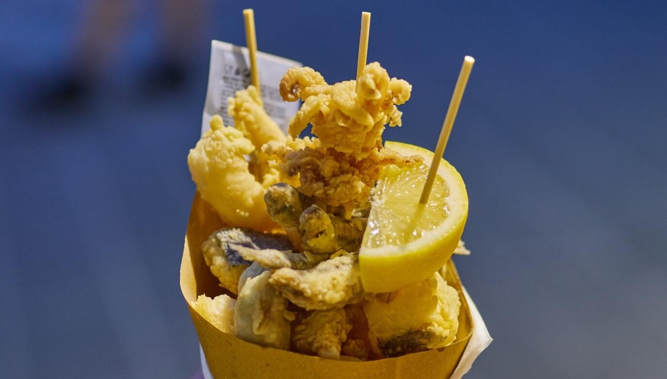 Cono di fritto misto di pesce, croccante e invitante, con spicchio di limone.