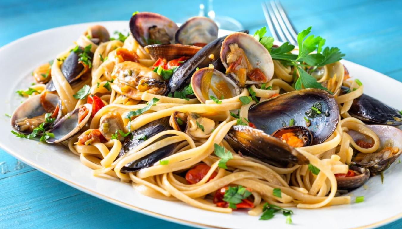 Piatto di linguine ai frutti di mare, fresco e invitante, con cozze e vongole.